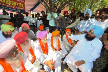 Punjab farmers rallying in Mohali protesting land acquisition with banners and signs.