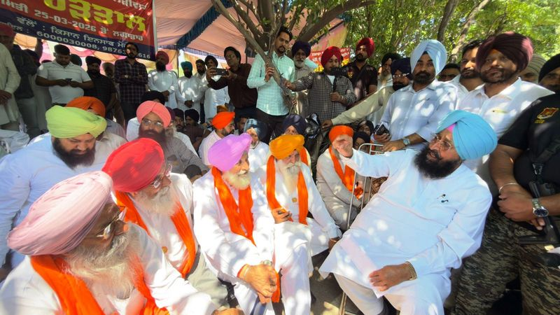 Punjab farmers rallying in Mohali protesting land acquisition with banners and signs.
